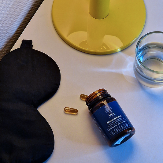 Flacon de gélules CBD sommeil ELEA et deux gélules dorées sur fond clair