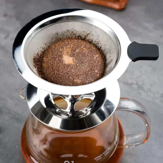 Infuseur à thé inox sur support, filtre à maille sombre en cours d’infusion