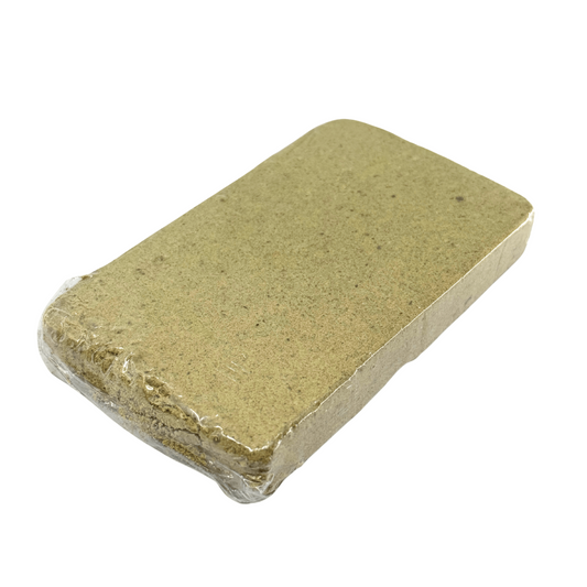 Bloc de résine jaune emballé sous film plastique, surface granuleuse rectangulaire.
