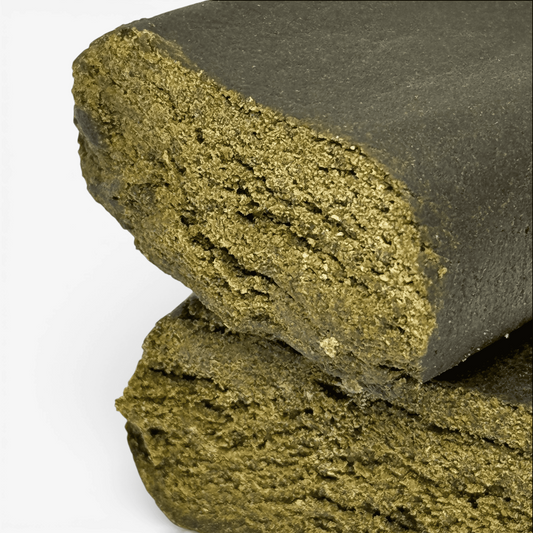 Résine CBD solide vert olive, surface granuleuse et cassure nette.