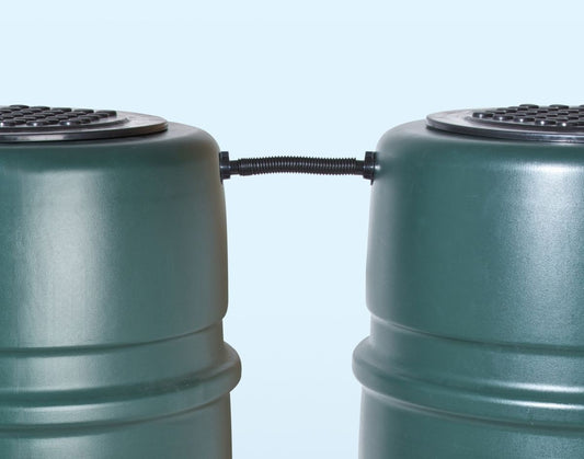 Tuyau de liaison noir reliant deux réservoirs d’eau verts