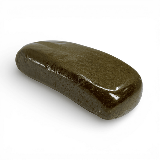 Bloc de résine CBD vert olive, forme cylindrique aplatie, texture granuleuse.