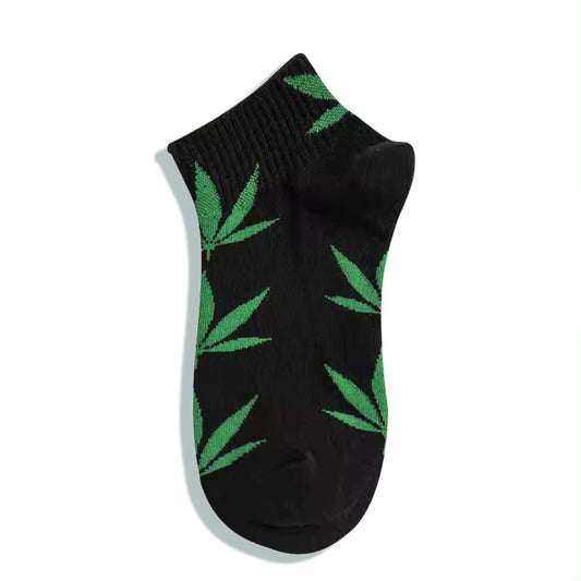 Chaussette noire à motifs de feuilles de cannabis vertes, vue de dessus.