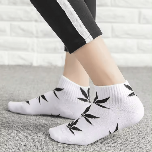 Chaussettes blanches motifs feuilles cannabis noires, bord côtelé.