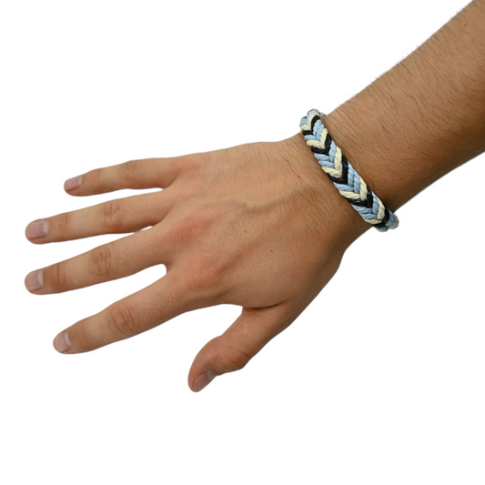 Bracelet en corde de chanvre tressée multicolore au poignet.