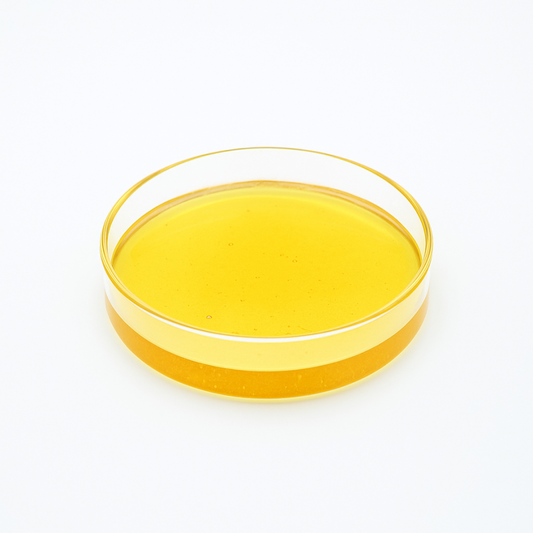 Distillat CBG jaune ambré dans un récipient en verre, texture épaisse