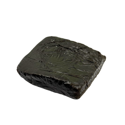 Bloc de résine sombre noir-vert, surface froissée et luisante