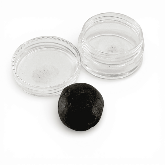 Crème CBD en pot transparent, pastille de résine noire et couvercle posé