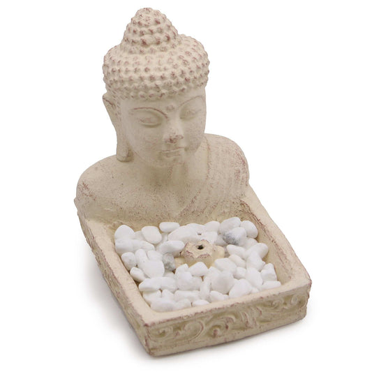 Porte-encens bouddha en béton clair, visage sculpté, plateau rempli de petites pierres blanches.