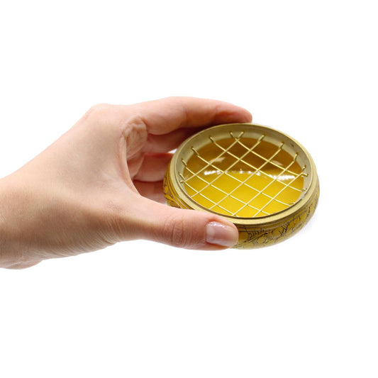 Couvercle doré ajouré avec grille pour bol à encens, tenu par la main