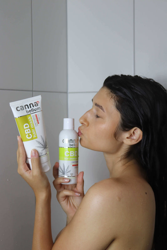 Shampoing CBD Cannabellum en flacon blanc, femme tenant le produit