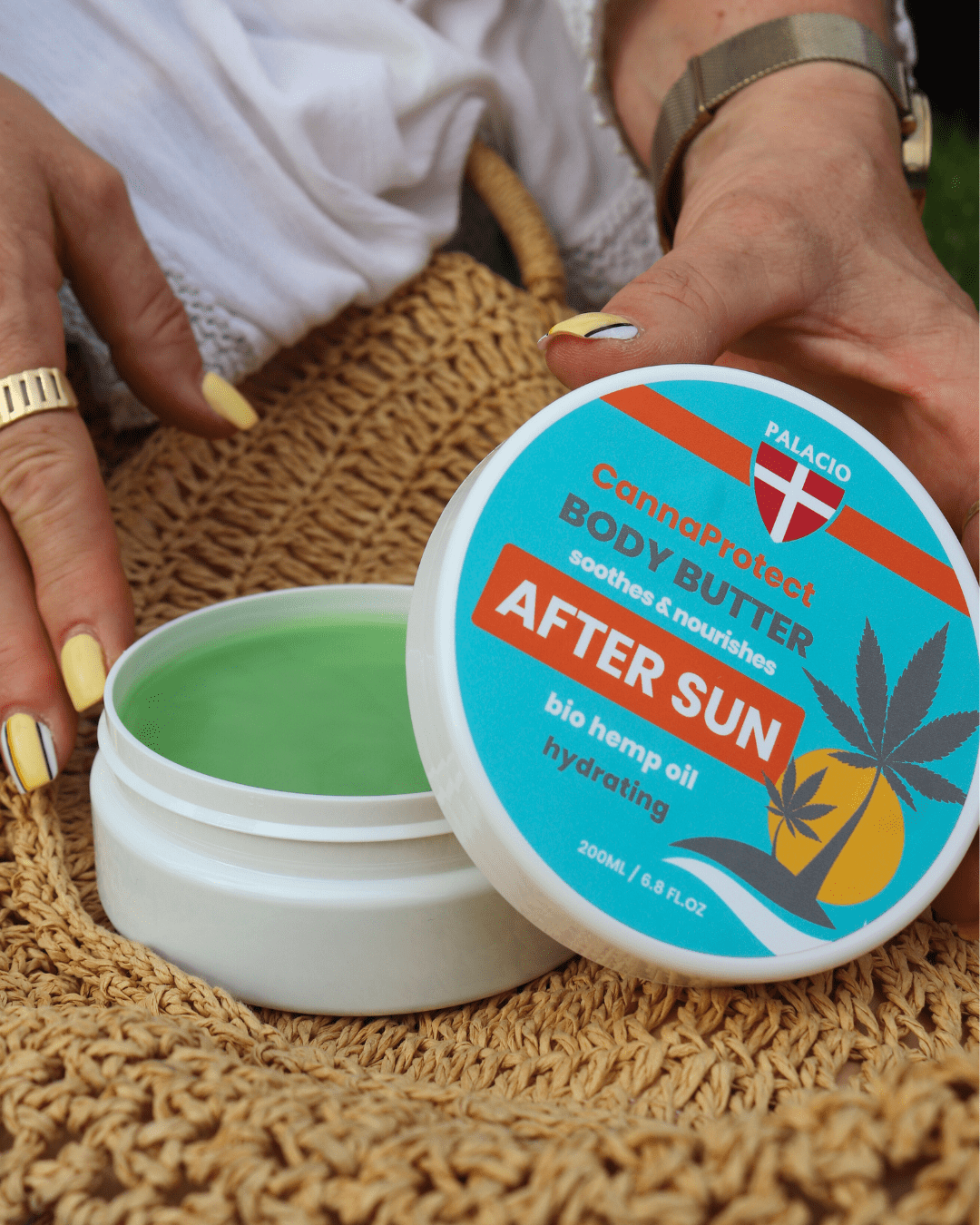 Pot de beurre corporel après-soleil au chanvre ouvert avec crème verte, mains en train d’appliquer