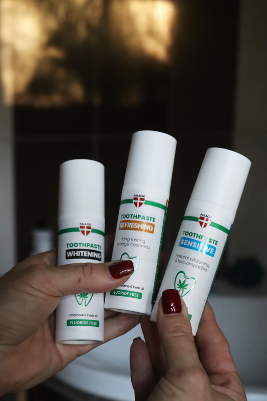 Trois tubes de dentifrice Palacio blancs en main, étiquettes blanchissant, sensible, fraîcheur.