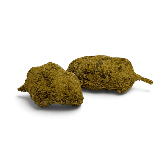 Morceau de moonrock CBD compact, vert, texture granuleuse, brins épars.